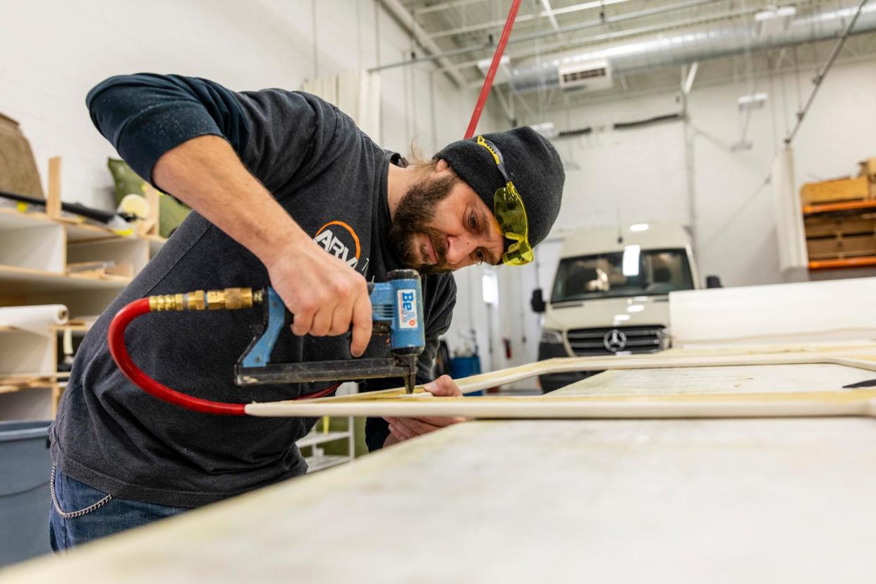 <span>An Advanced RV employee works on wall panels in Willoughby, Ohio, in 2023.</span><span>Photograph: Amber Ford</span>