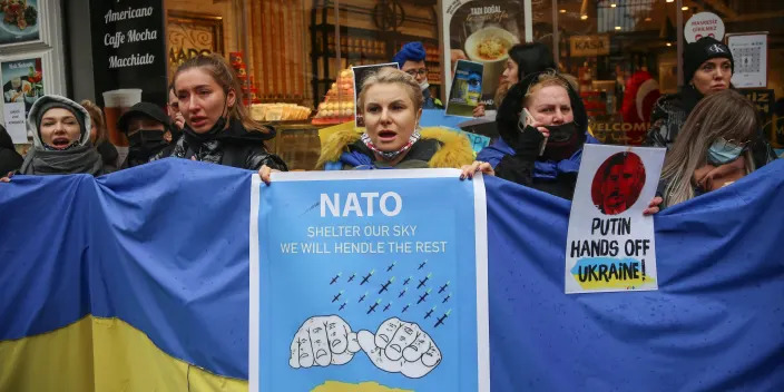 Protesters hold a sign that says 