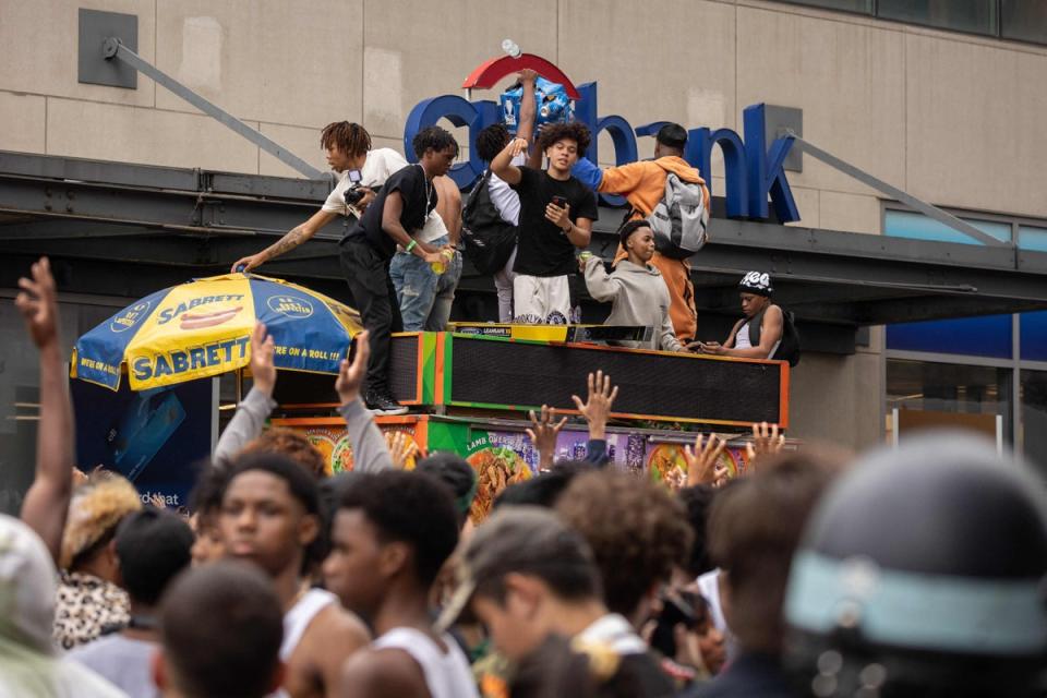 People stand on top of a street vendor's cart during the riot (AFP via Getty Images)