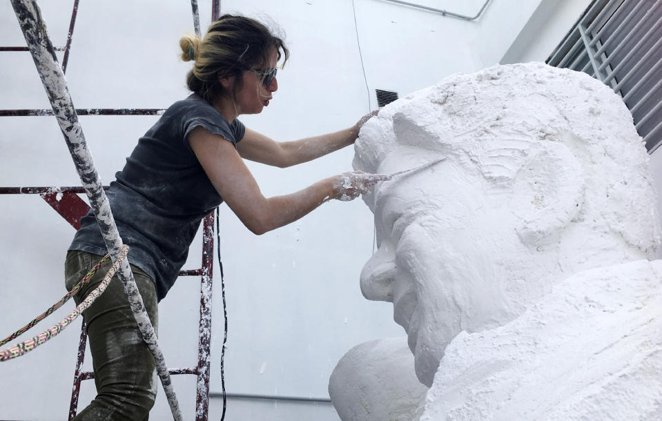 In this Nov. 11, 2019 photo, artist Mercedes Savall works on a statue that depicts River Plate coach Marcelo Gallardo, in Buenos Aires, Argentina. The statue is in recognition of the ten titles he has garnered for River Plate. (AP Photo/Debora Rey)