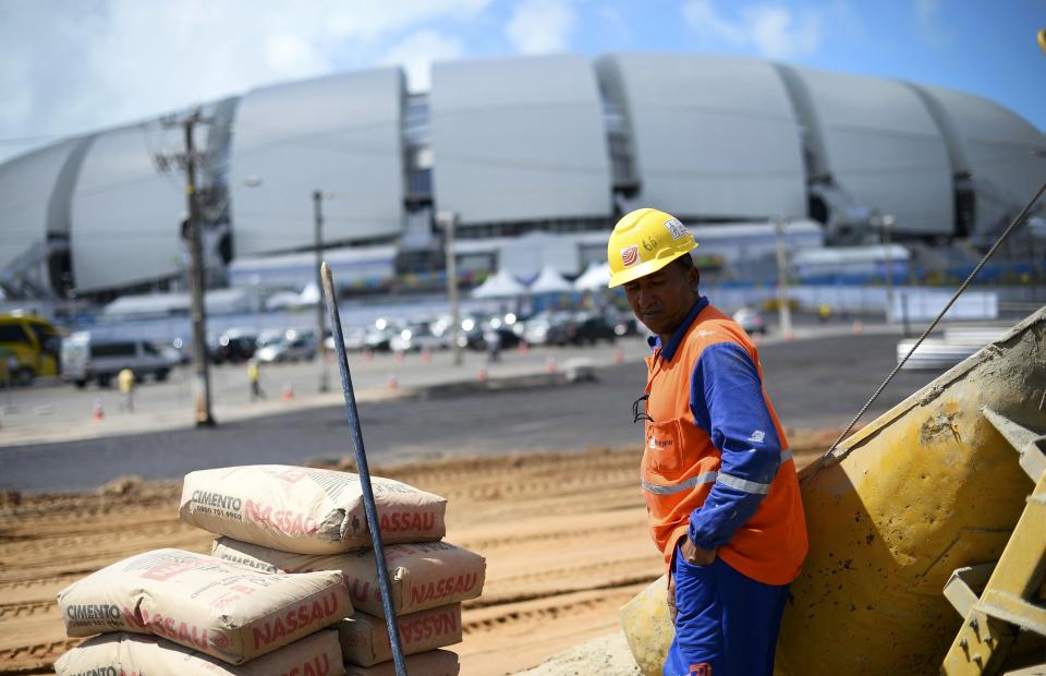 A construction worker rests in the midday sun next to the Dunas arena soccer stadium in Natal, June 12 , 2014. Mexico will face Cameroon in their 2014 World Cup football match here on June 13. REUTERS/Dylan Martinez