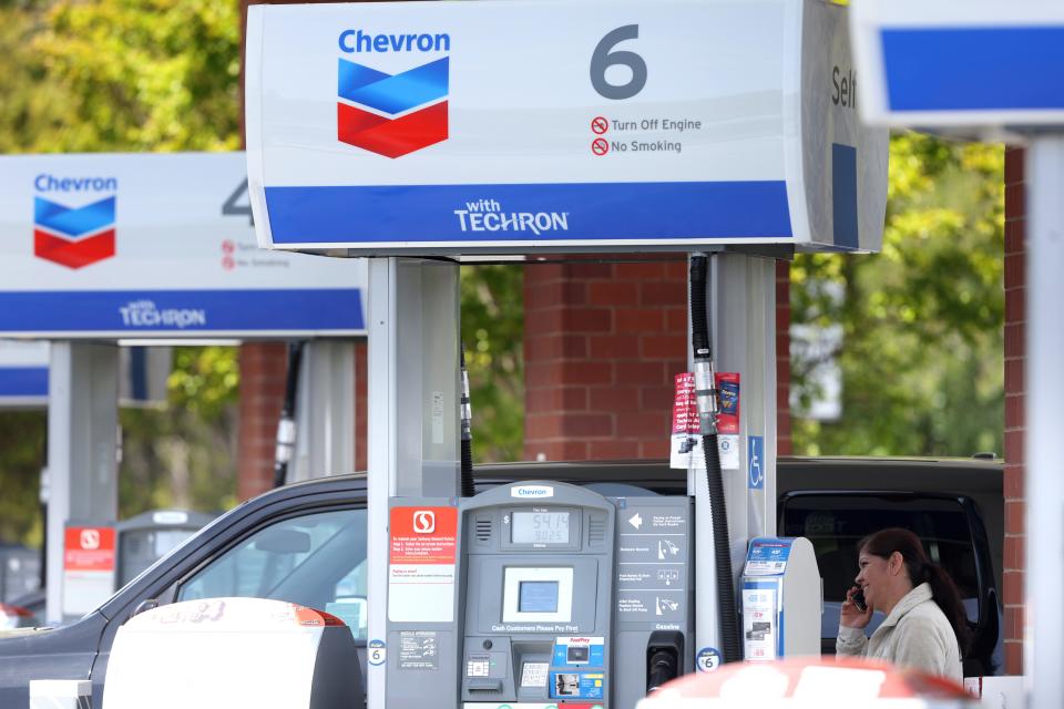 A customer talks on the phone while waiting for her car to fill up at a Chevron gas station on April 29, 2022 in Greenbrae, California.