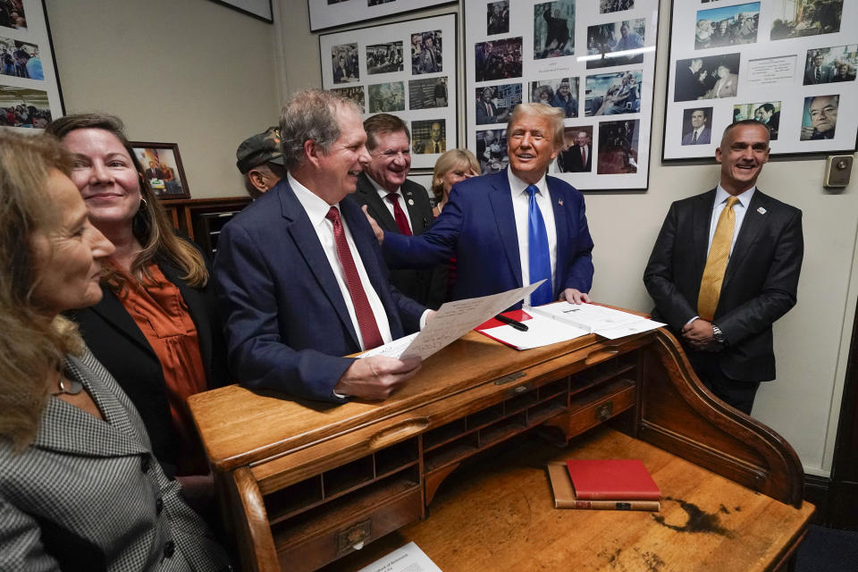 Republican presidential candidate former President Donald Trump talks as New Hampshire Secretary of State David Scanlan, third from left, listens as he signs papers to be on the 2024 Republican presidential primary ballot at the New Hampshire Statehouse, Monday, Oct. 23, 2023, in Concord, N.H. At right is Corey Lewandowski. (AP Photo/Charles Krupa)