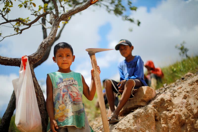 Indigenous children pose for a picture in a gold mine at the Santa Creuza community in the Raposa Serra do Sol reservation