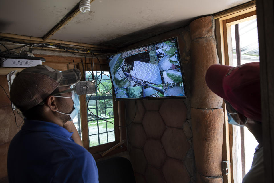 Seminarians monitor security cameras at the mission and drug rehab center run by Friar Leopoldo Serrano, located in a valley marked by poverty and drug violence, in Mission San Francisco de Asis, Honduras, Thursday, June 24, 2021. Serrano who is routinely observed by men passing by in oversized SUVs with tinted windows, complained to the prosecutor’s office which led to the installation of surveillance systems. (AP Photo/Rodrigo Abd)