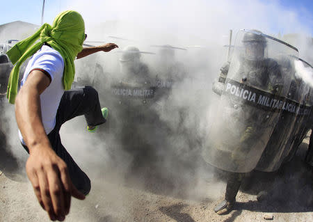 An activist kicks the shields of the military police officers during a demonstration in the military zone of the 27th infantry battalion in Iguala, Guerrero, January 12, 2015. REUTERS/Jorge Dan Lopez