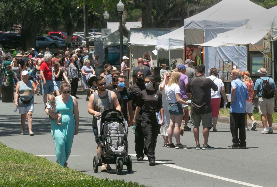 Festival attendees stroll along Lake Morton Drive during the annual Mayfaire by-the Lake.