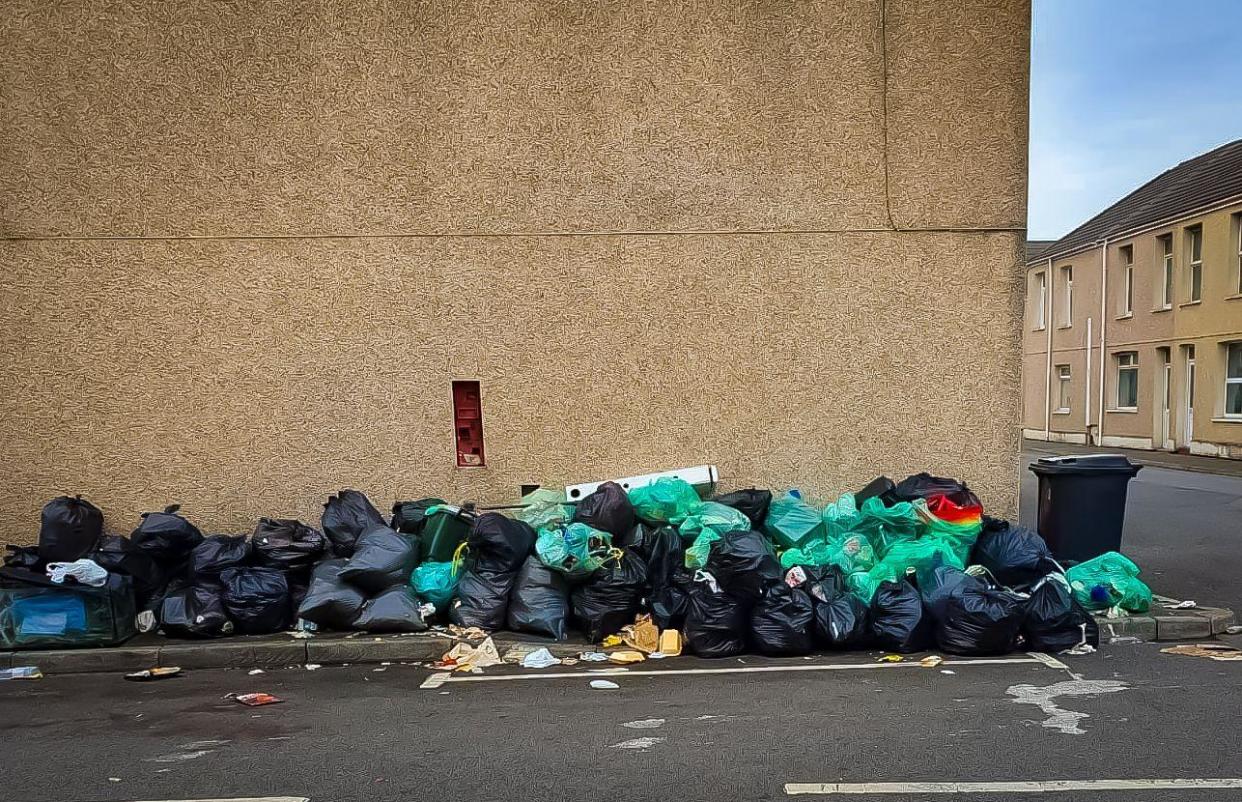 Rubbish bags completely cover a pavement on an area of row housing in Aberavon