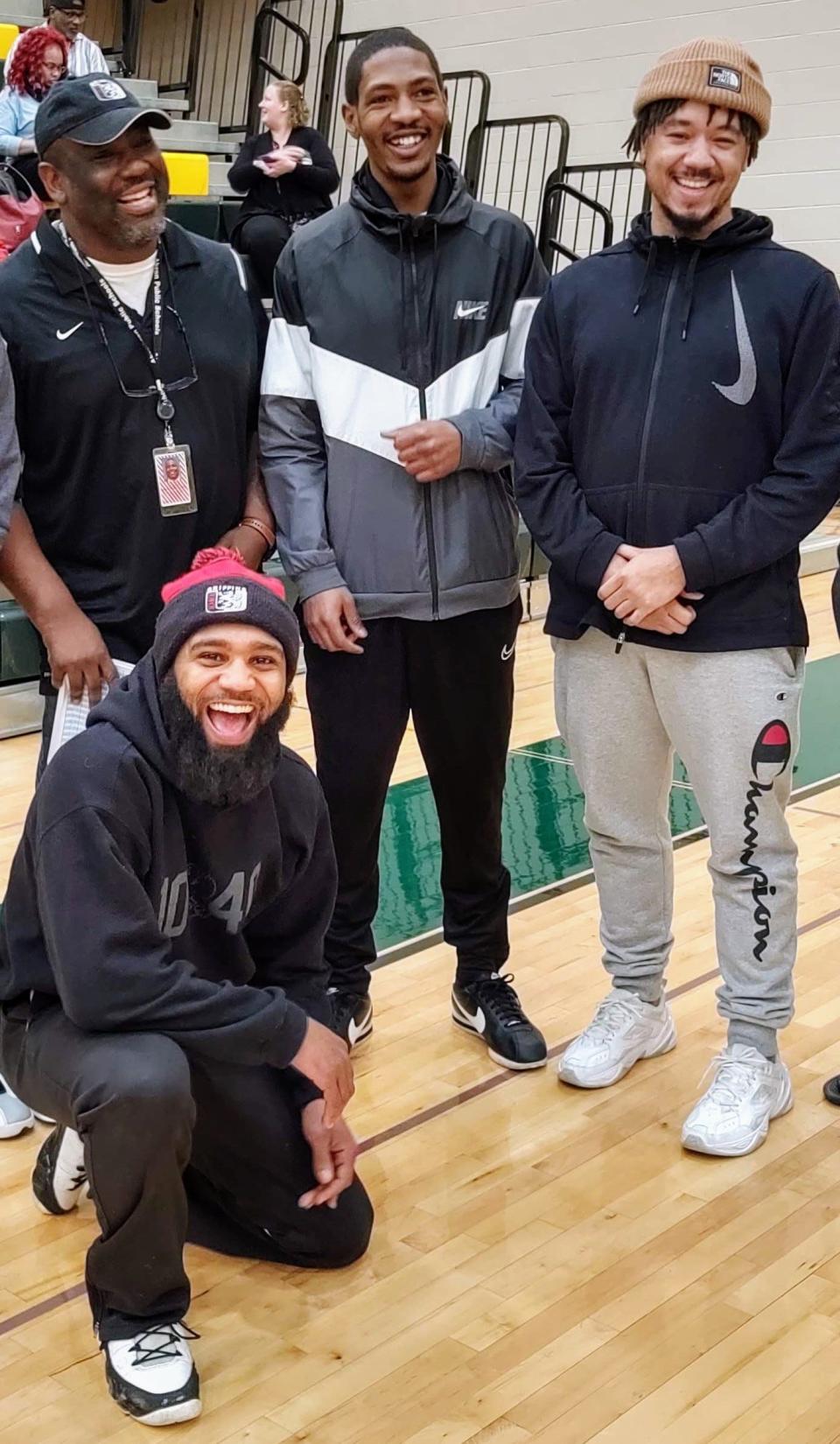 Jayland Walker, center, was killed by Akron police on June 27 following a car chase. This photo is from a wrestling tournament in 2020 that Walker went to watch. He is shown with, from left, his former Buchtel wrestling coach Robert Hubbard and fellow alumni Jarren Watts and Blake Lewis, kneeling.