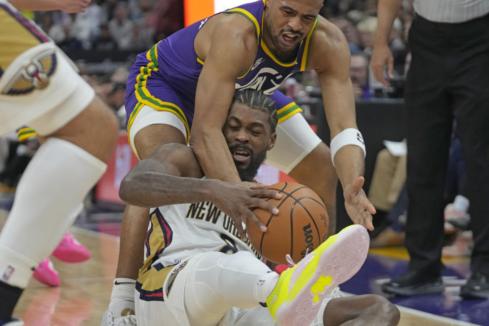 Utah Jazz guard Talen Horton-Tucker, rear, and New Orleans Pelicans forward Naji Marshall battle for a loose ball during the first half of an NBA basketball game, Monday, Nov. 27, 2023, in Salt Lake City. (AP Photo/Rick Bowmer)