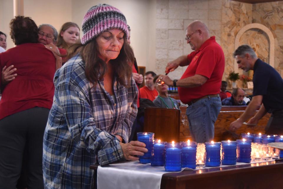 Lisa-Marie Foster places a candle on the table. Thursday was the winter solstice, the longest night of the year. It was also the Homeless Persons' Memorial Day. Three ceremonies were held around the county, including this one at our Lady of Lourdes Catholic Church. As the names were read of all the homeless people who died in Brevard this year, people lit votive candles in their memory.