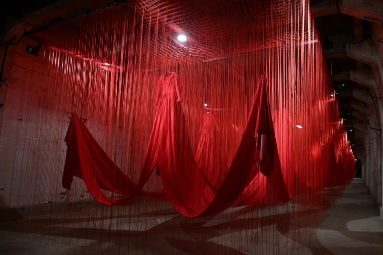 Une installation de cordes rouges et de robes flottant dans le tunnel de l'ancien camp de concentration d'Ebensee, lors du vernissage de l'exposition de l'artiste japonaise Chiharu Shiota, le 26 avril 2024 en Autriche (KERSTIN JOENSSON)
