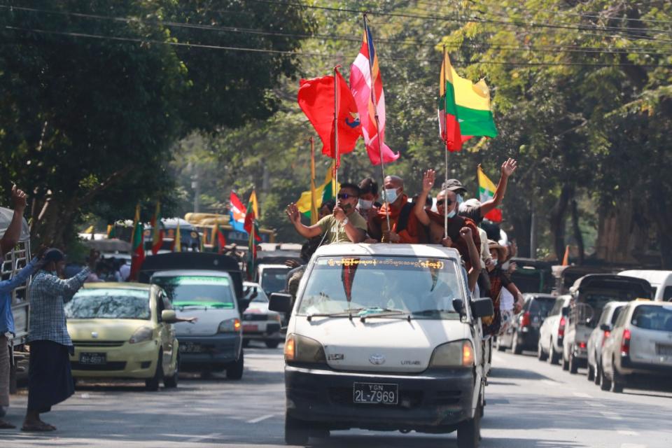 Buddhist religious and military flags are waved by supporters including Buddhist monks onboard a vehicle on Feb. 1, 2021, in Yangon, Myanmar. 