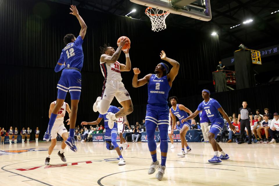 Florida Atlantic guard Alijah Martin (15) shoots between Middle Tennessee guard Teafale Lenard Jr. (12) and forward Tyler Millin (1) during the first half of a Conference USA NCAA college basketball semifinal game in Frisco, Texas, Friday, March 10, 2023. (AP Photo/Michael Ainsworth)