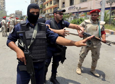 Policemen and army personnel at the site of a car bomb attack on the convoy of Egyptian public prosecutor Hisham Barakat near his house at Heliopolis district in Cairo, Egypt, June 29, 2015. REUTERS/Mohamed Abd El Ghany