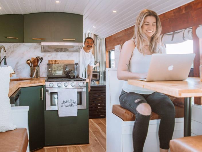 The writer working on a laptop at small table on school bus