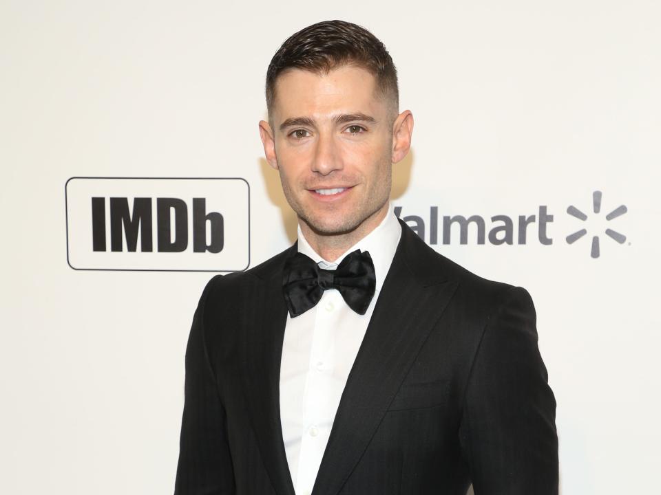 Julian Morris in a tuxedo and black bowtie with a white background