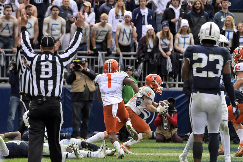 Illinois wide receiver Casey Washington (14) celebrates after catching a pass for a 2-point conversion in the ninth overtime to defeat Penn State 20-18 in an NCAA college football game in State College, Pa.on Saturday, Oct. 23, 2021. (AP Photo/Barry Reeger)