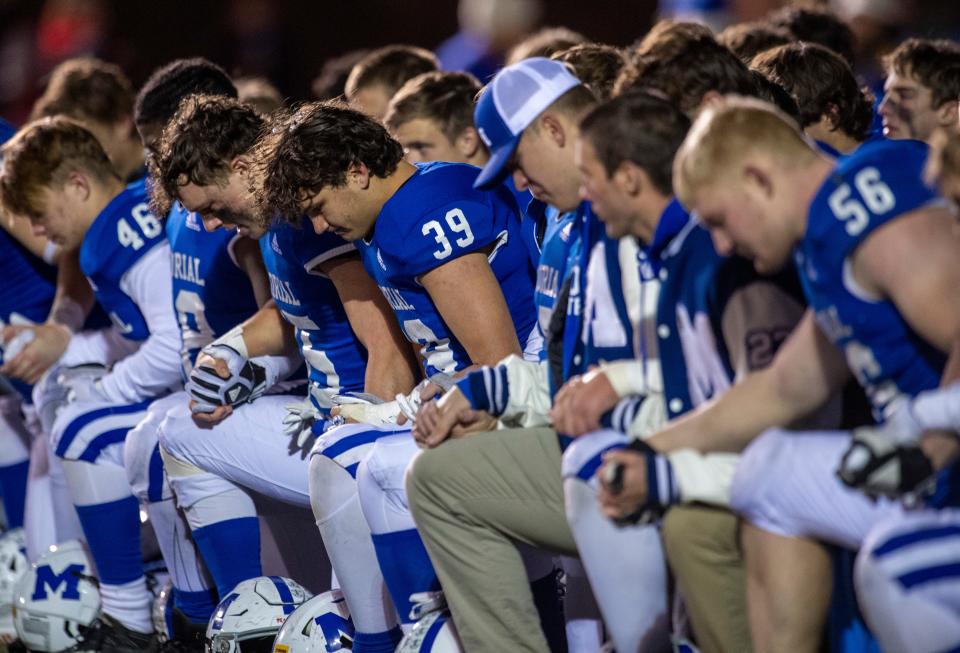 The Memorial Tigers pray after falling to the East Central Trojans in the IHSAA 4A regional #12 at Enlow Field in Evansville, Ind., Friday evening, Nov. 11, 2022. 