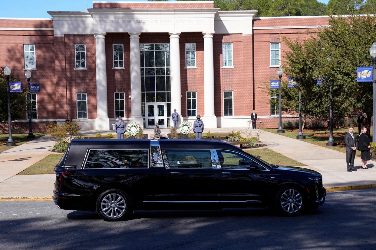 The hearse carrying casket of former first lady Rosalynn Carter pauses as family members participate in a wreath laying ceremony (AP)