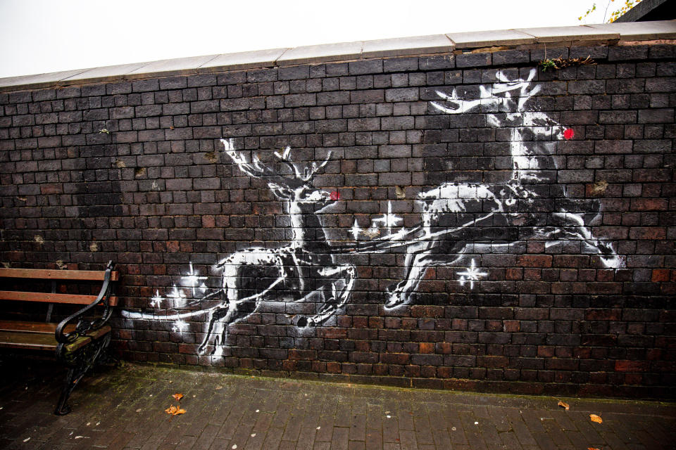 The Banksy mural in Birmingham shows two painted reindeer appearing to pull along a real bench. (Photo: Jacob King - PA Images via Getty Images)