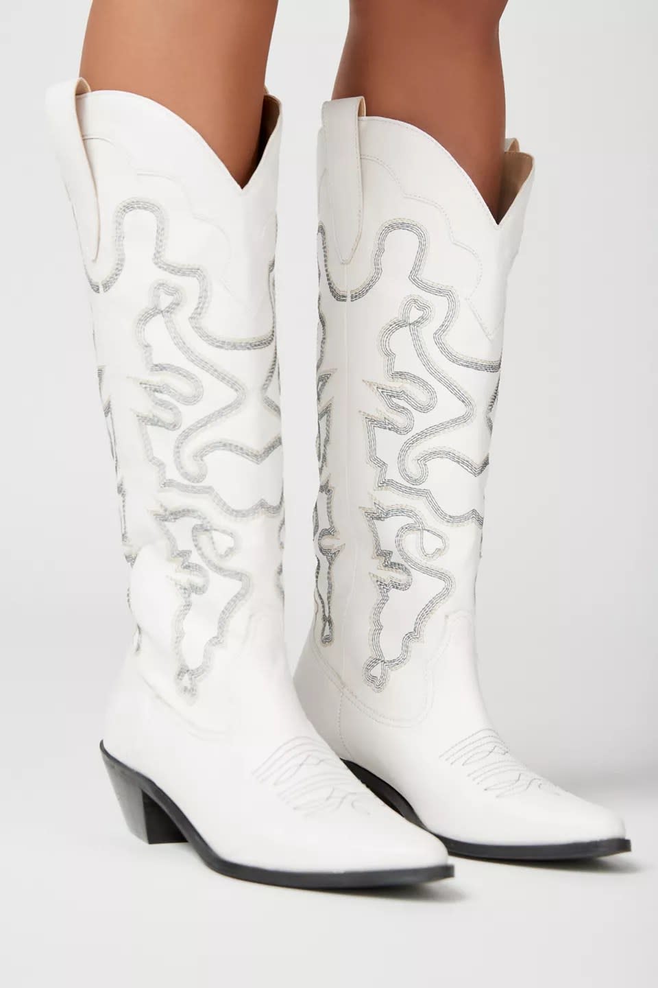 model wearing tall white and silver cowboy boots