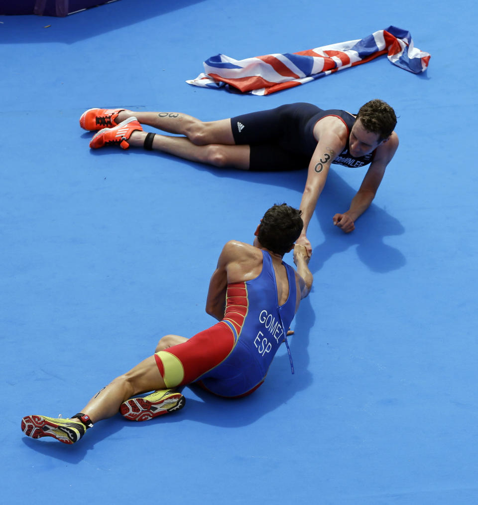 Great Britain's Alistair Brownlee, top, is congratulated by Spain's Javier Gomez after Brownlee won the gold medal in the men's triathlon at the 2012 Summer Olympics, Tuesday, Aug. 7, 2012, in London. Gomez took the silver. (AP Photo/Darron Cummings)