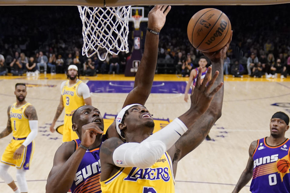 Los Angeles Lakers forward Jarred Vanderbilt, right, shoots as Phoenix Suns center Bismack Biyombo defends during the first half of an NBA basketball game Wednesday, March 22, 2023, in Los Angeles. (AP Photo/Mark J. Terrill)
