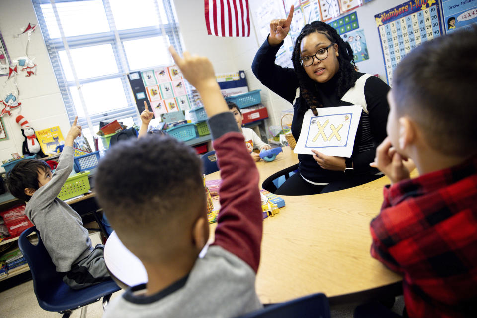 Student teacher Lana Scott, who plans to graduate from Bowie State University in the spring of 2023, teaches a small group of kindergartners at Whitehall Elementary School the alphabet, Tuesday, Jan. 24, 2023, in Bowie, Md. (AP Photo/Julia Nikhinson)