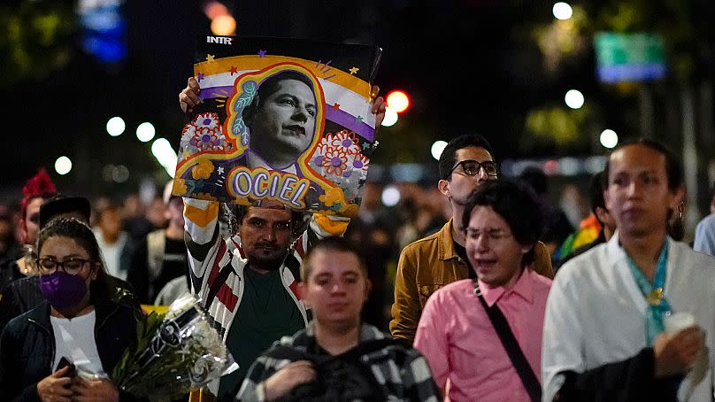 Demonstrators march with a picture of Aguascalientes state electoral court magistrate Jesus Ociel Baena in Mexico City