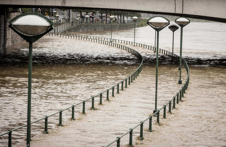 Light posts along a pathway of the Meuse river as it rises during flooding in Liege, Belgium, Thursday, July 15, 2021. Heavy rainfall is causing flooding in several provinces in Belgium with rain expected to last until Friday. (AP Photo/Valentin Bianchi)