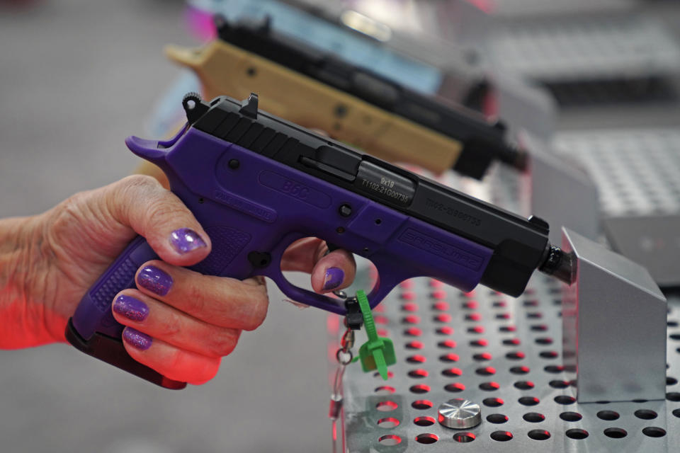 A woman grips a pistol at the annual meeting Friday.  (Allison Dinner for NBC News)