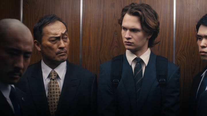 Two men look at each other in the elevator in Tokyo Vice.