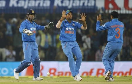 India's captain Mahendra Singh Dhoni (L) and Suresh Raina celebrate the dismissal of South Africa's Farhaan Behardien during their second one-day international cricket match in Indore, India, October 14, 2015. REUTERS/Danish Siddiqui