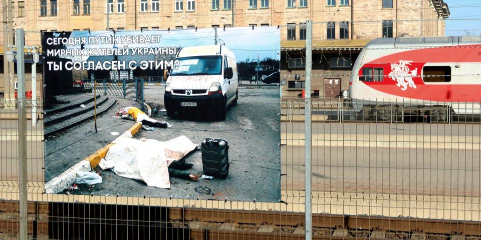 A poster with a picture taken by Ukrainian photographer Maxim Dondyuk of a war scene, amid Russia's invasion of Ukraine, is displayed for Russian passengers on their way between Kaliningrad exclave and mainland Russia at Vilnius railway station, Lithuania March 25, 2022.