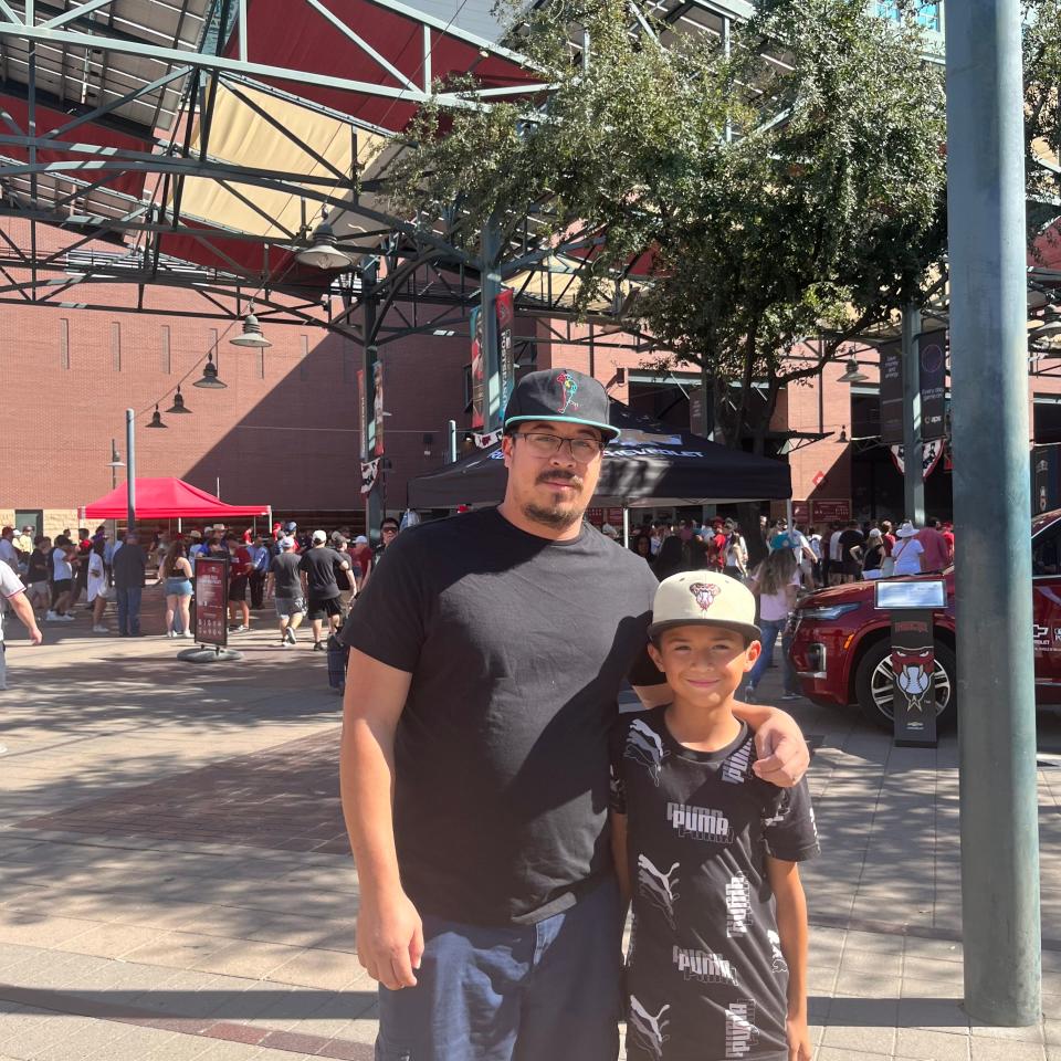 Diamondbacks fans Mario Chavez and his son stand outside Chase Field on Oct. 19, 2023.