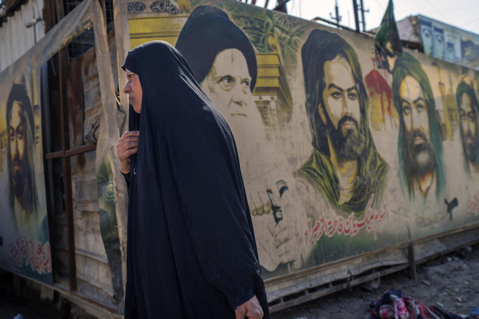 A veiled woman walks through the Sadr City neighborhood of Baghdad, Iraq, Wednesday, March 1, 2023. This working-class, conservative and largely Shiite suburb in eastern Baghdad is home to more than 1.5 million people. (AP Photo/Jerome Delay)