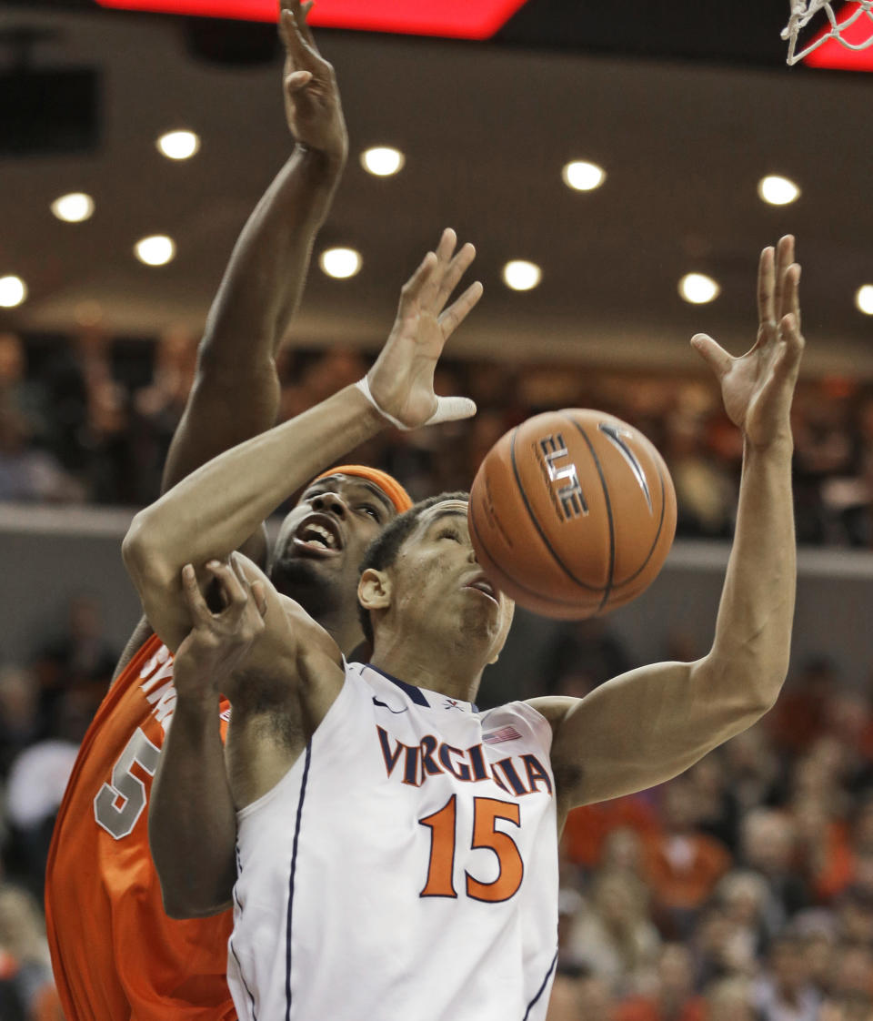 Virginia guard Malcolm Brogdon (15) and Syracuse forward C.J. Fair (5) fight for a rebound during the first half of an NCAA College basketball game in Charlottesville, Va., Saturday, March 1, 2014. (AP Photo/Steve Helber)