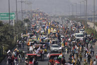 FILE - In this Tuesday, Jan. 26, 2021, file photo, farmers participate in a tractor protest rally towards the capital during India's Republic Day in New Delhi, India. A sea of tens of thousands of farmers riding tractors and horses stormed India’s historic Red Fort on Jan. 26, a dramatic escalation of their protests, which are posing a major challenge to Prime Minister Narendra Modi's government. They are demanding the repeal of laws passed by Parliament in September that they say will favor large corporate farms, devastate the earnings of many farmers and leave those who hold small plots behind as big corporations win out. (AP Photo/Dinesh Joshi, File)