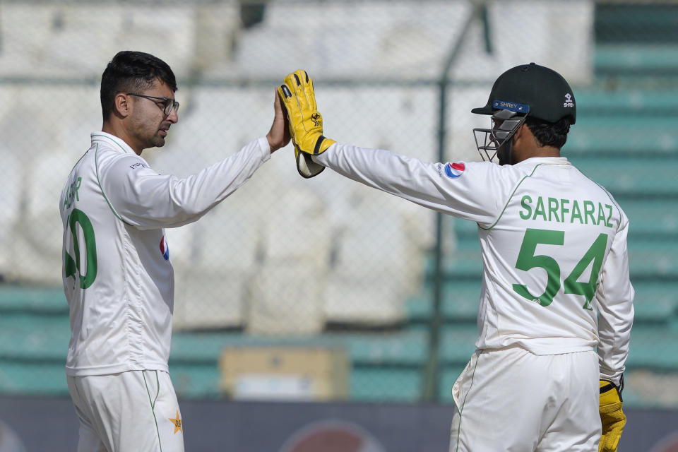 Pakistan's Abrar Ahmed, left, celebrates with teammate Sarfraz Ahmed after taking the wicket of New Zealand's Neil Wagner during the fourth day of first test cricket match between Pakistan and New Zealand, in Karachi, Pakistan, Thursday, Dec. 29, 2022. (AP Photo/Fareed Khan)