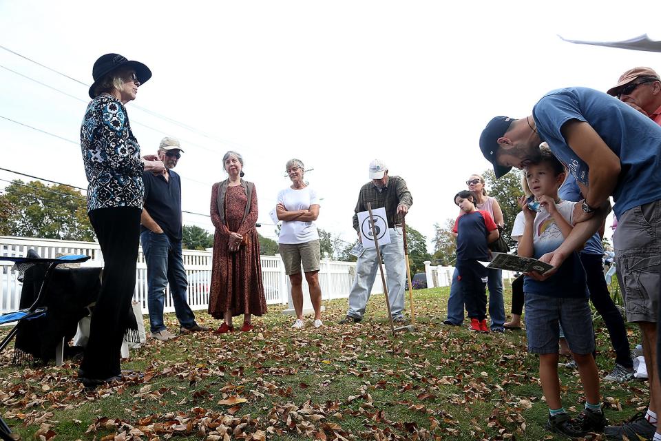 Betsy Gordon talks about the life of Eleanor Norris, who donated the land that would become the Norris Reservation to the Trustees of Reservations, while Norwell native Richard Freed attends the tour with his son, James, 5, during the Norwell Historical Society’s "First Parish Cemetery Comes Alive" program on Saturday, Oct. 16, 2021.