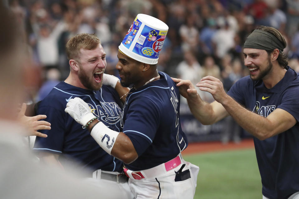 Tampa Bay Rays' Yandy Diaz, center, celebrates with teammates Luke Raley, left and Josh Lowe after hitting a walk off two-run home run against the Seattle Mariners during a baseball game Saturday, Sept. 9, 2023, in St. Petersburg, Fla. (AP Photo/Scott Audette)