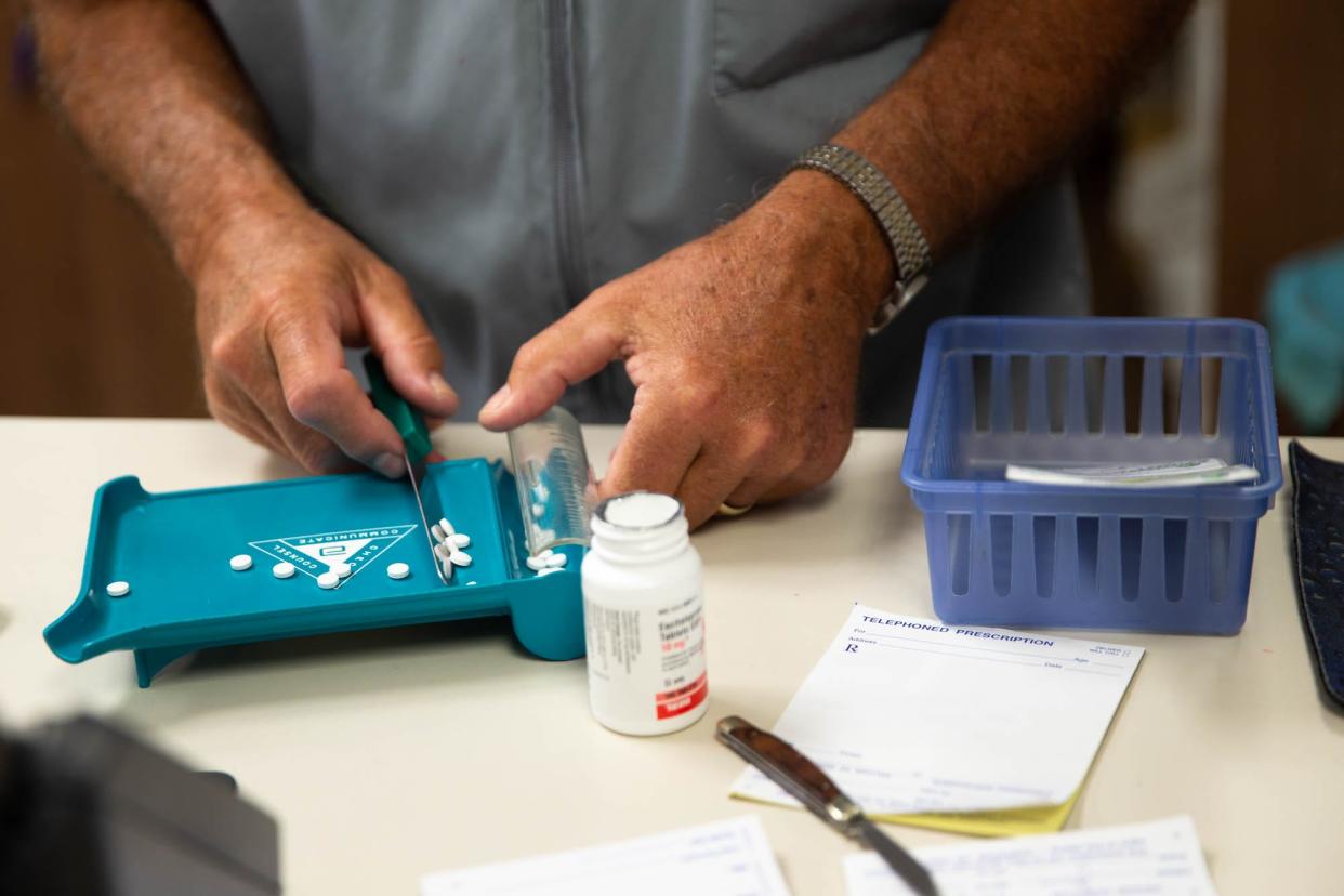 A pharmacist works to fill prescriptions.