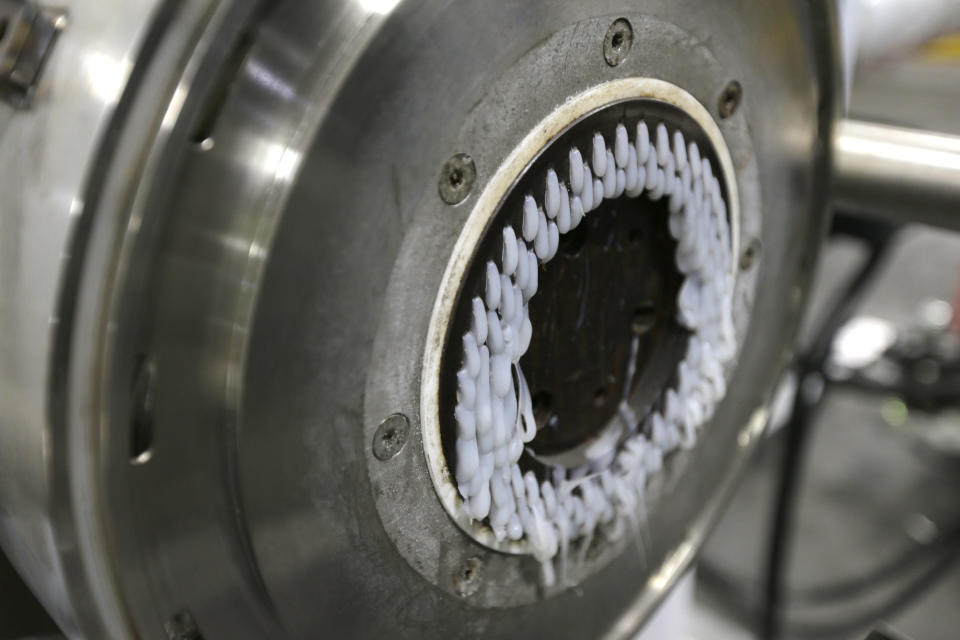 In this May 7, 2019 photo, a machine that produces plastic pellets from plastic film is seen in operation at a GDB International warehouse in New Brunswick, N.J. GDB International exported bales of scrap plastic film such as pallet wrap and grocery bags for years. But when China started restricting imports, company president Sunil Bagaria installed new machinery to process it into pellets he sells profitably to manufacturers of garbage bags and plastic pipe. (AP Photo/Seth Wenig)