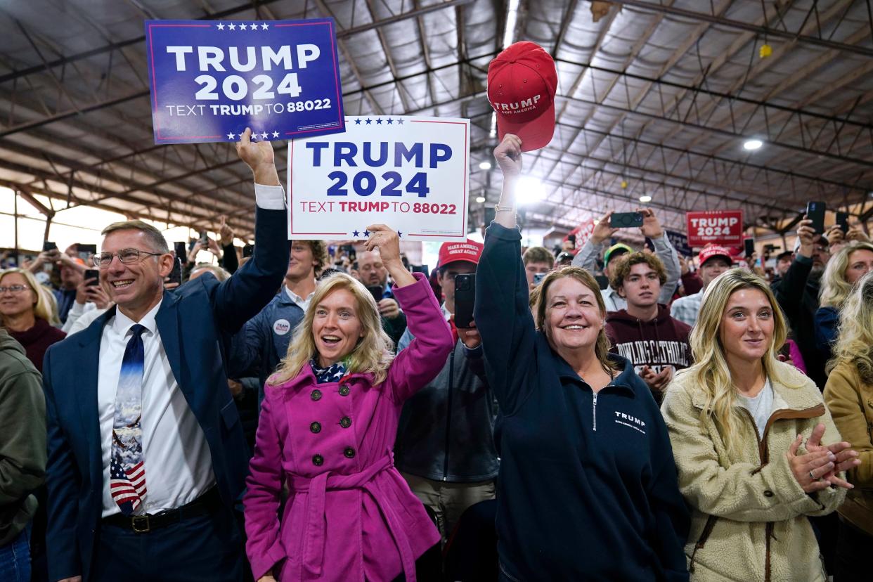 Audience members react as former President Donald Trump arrives at a commit to caucus rally, Monday, Oct. 16, 2023, in Adel, Iowa. (AP Photo/Charlie Neibergall)
