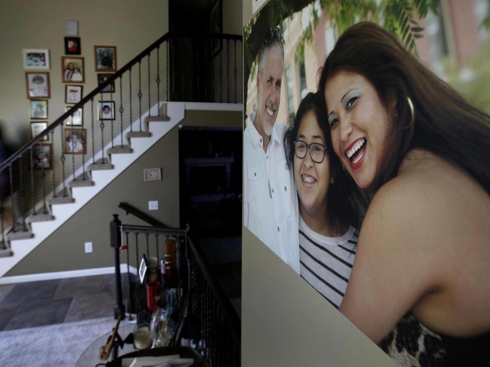 Jennifer Tadeo-Uscanga, 17, walks down a staircase lined with family photos at the Kansas City, Missouri (AP Photo/Charlie Riedel)