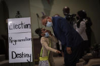 Bishop Ronnie Crudup listens to his granddaughter at a church service at the New Horizon International Church, Sunday, Oct. 4, 2020, in Jackson, Miss. "I don't agree with Donald Trump. I don't agree with his politics. I've already said so," Crudup said. "But that doesn't mean we can't pray for his life." (AP Photo/Wong Maye-E)