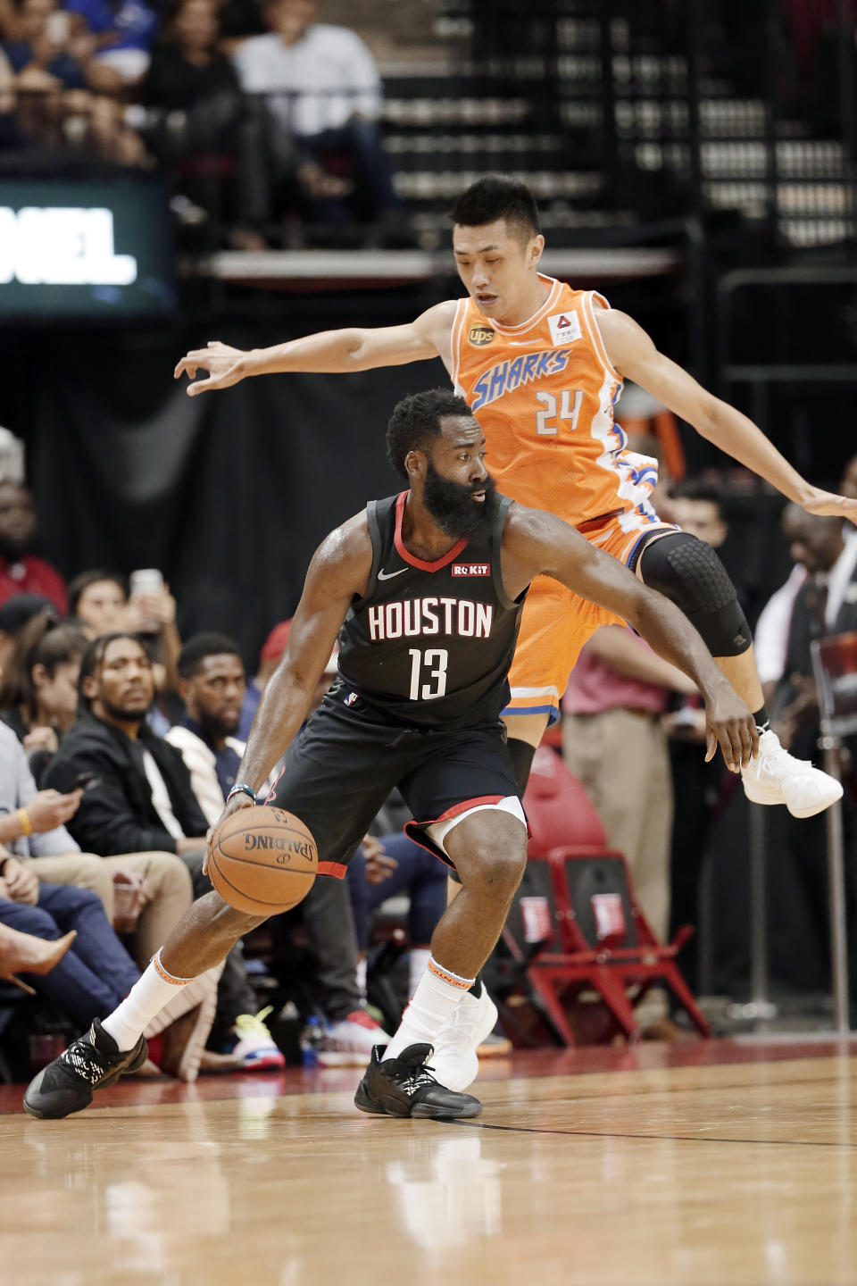 Houston Rockets guard James Harden (13) drives under Shanghai Sharks forward Ju Mingxin (24) during the first half of an NBA basketball preseason game Monday, Sept. 30, 2019, in Houston. (AP Photo/Michael Wyke)
