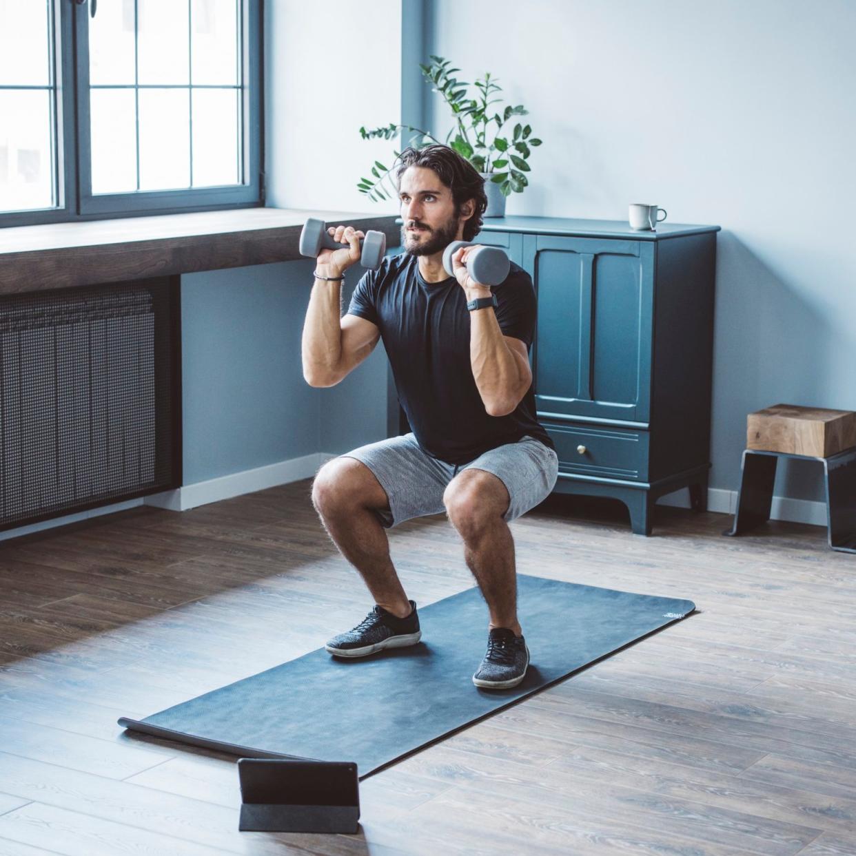 man squatting with weights