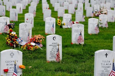 A U.S. flag stands next to the grave marker of U.S. Army Staff Sergeant Ayman Taha inside of Section 60 in Arlington National Cemetery on Memorial Day, May 30, 2016. REUTERS/Lucas Jackson